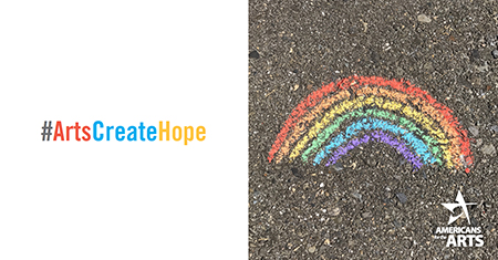 A photo of a chalk rainbow drawn on asphalt and the hashtag #ArtsCreateHope