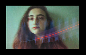 A portrait of a person with long brown-red hair against a plain background. In the foreground, an upward moving red line and a narrow, blue, waveform has been digitally superimposed.
