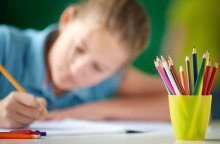 Student pictured coloring at desk 