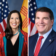 Side by side photos - a person with long dark hair wearing a red and turquoise blazer in front of the US and New Mexico flags, and a person with short dark hair wearing a suit and tie in front of the US flag.
