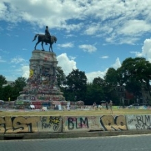 A distant view of a Robert E. Lee memorial statue covered in graffiti.