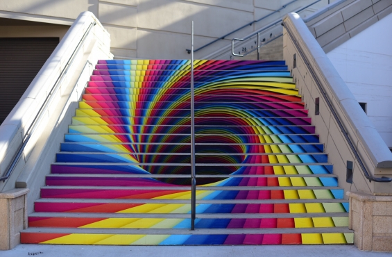 A set of stairs with a swirling rainbow vortex effect painted on them